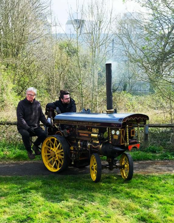 Two drivers with miniature traction engines wait to go for a run.